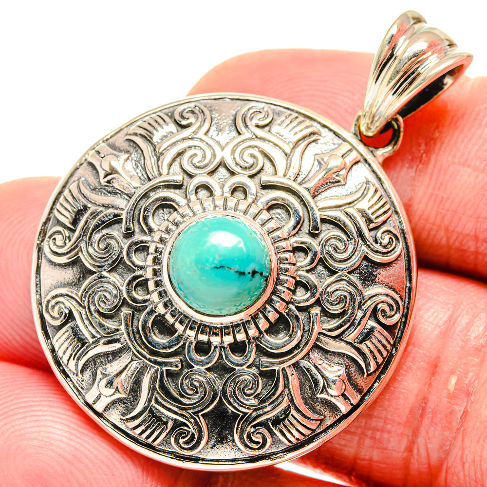 Silver-tone Tibetan turquoise pendant with ornate bezel and turquoise cabochon