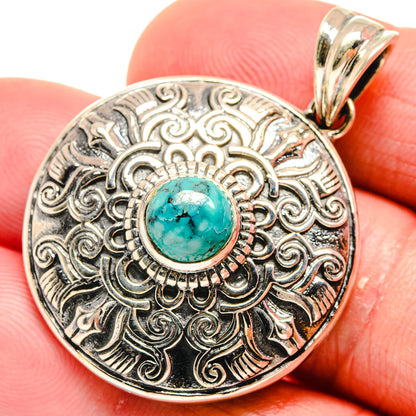 Close-up round 925 sterling silver pendant with turquoise cabochon and engraved frame