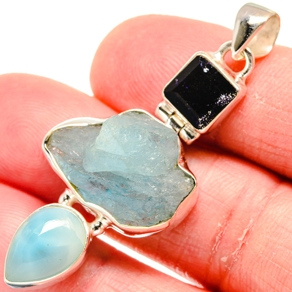 Sterling silver pendant close-up: rough aquamarine, light blue teardrop, dark blue square