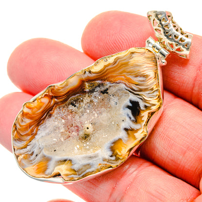 Orange-and-gold geode pendant with glittering white stone and ornate silver bail