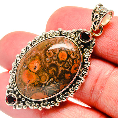 Oval poppy jasper cabochon pendant with ornate 925 sterling silver frame, garnet accents