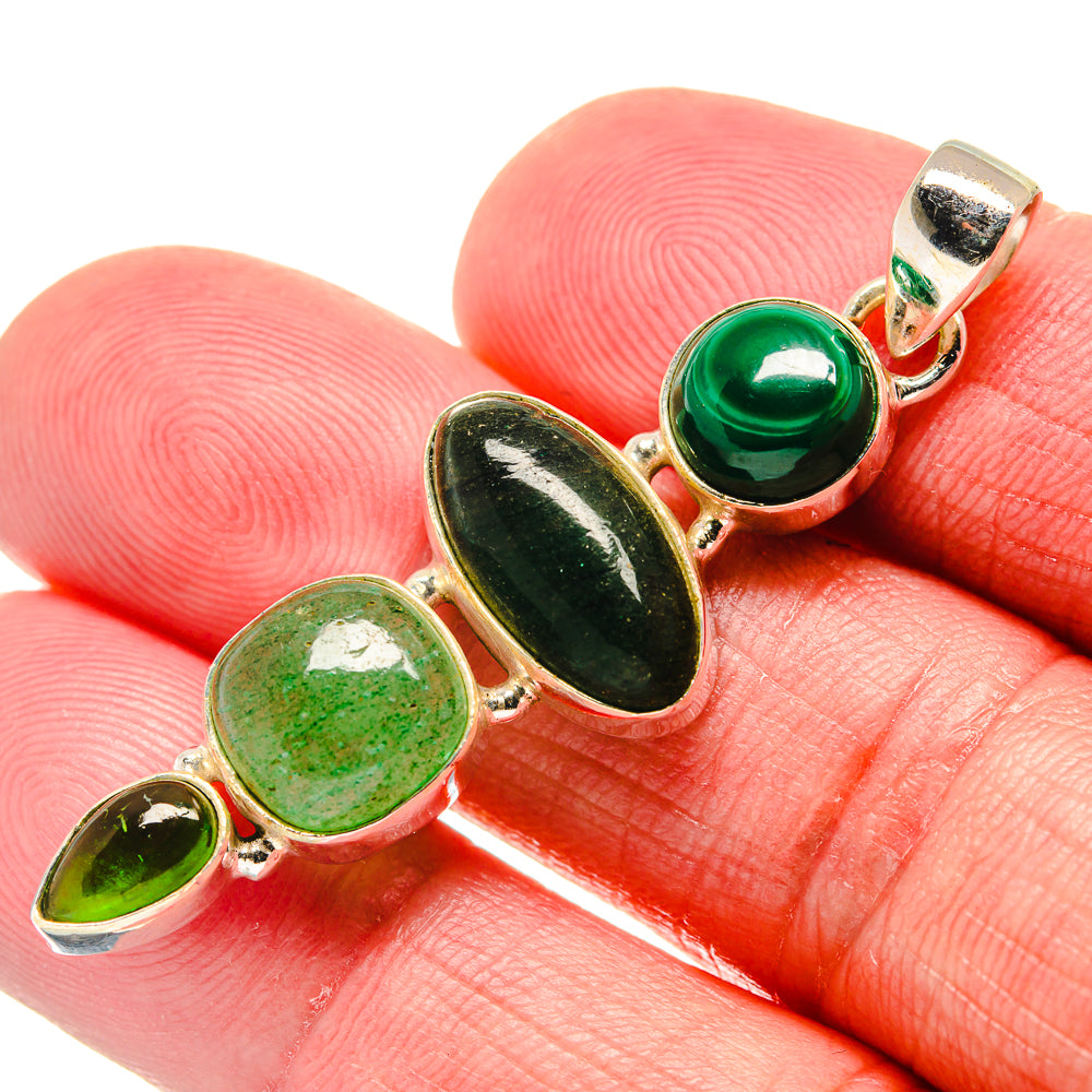 Green oval gemstone pendant with gold-tone bezel settings close-up