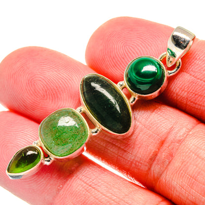 Green oval gemstone pendant with gold-tone bezel settings close-up