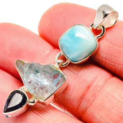 Silver pendant with oval aqua cabochon, rough pale stone, and purple teardrop accent