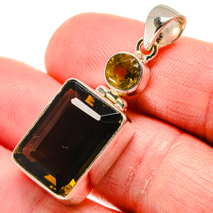 Smoky quartz pendant on silver bail with amber round stone, shown on fingertip