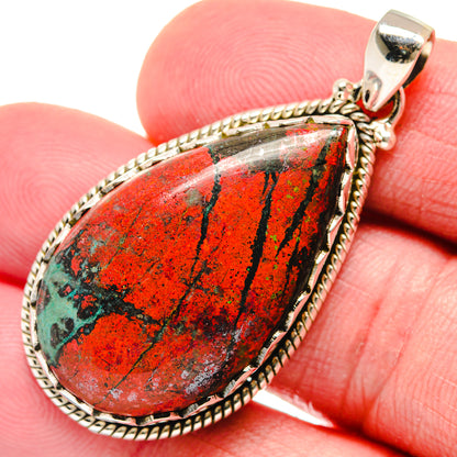 925 silver teardrop pendant with red-green stone on jump ring bail, held in fingers