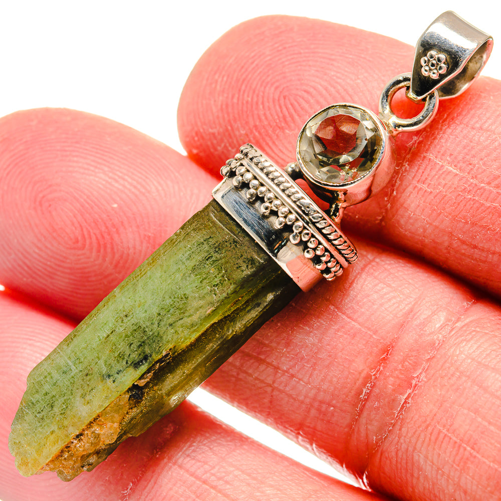 Sterling silver pendant close-up with rough green crystal and round faceted stone, bail
