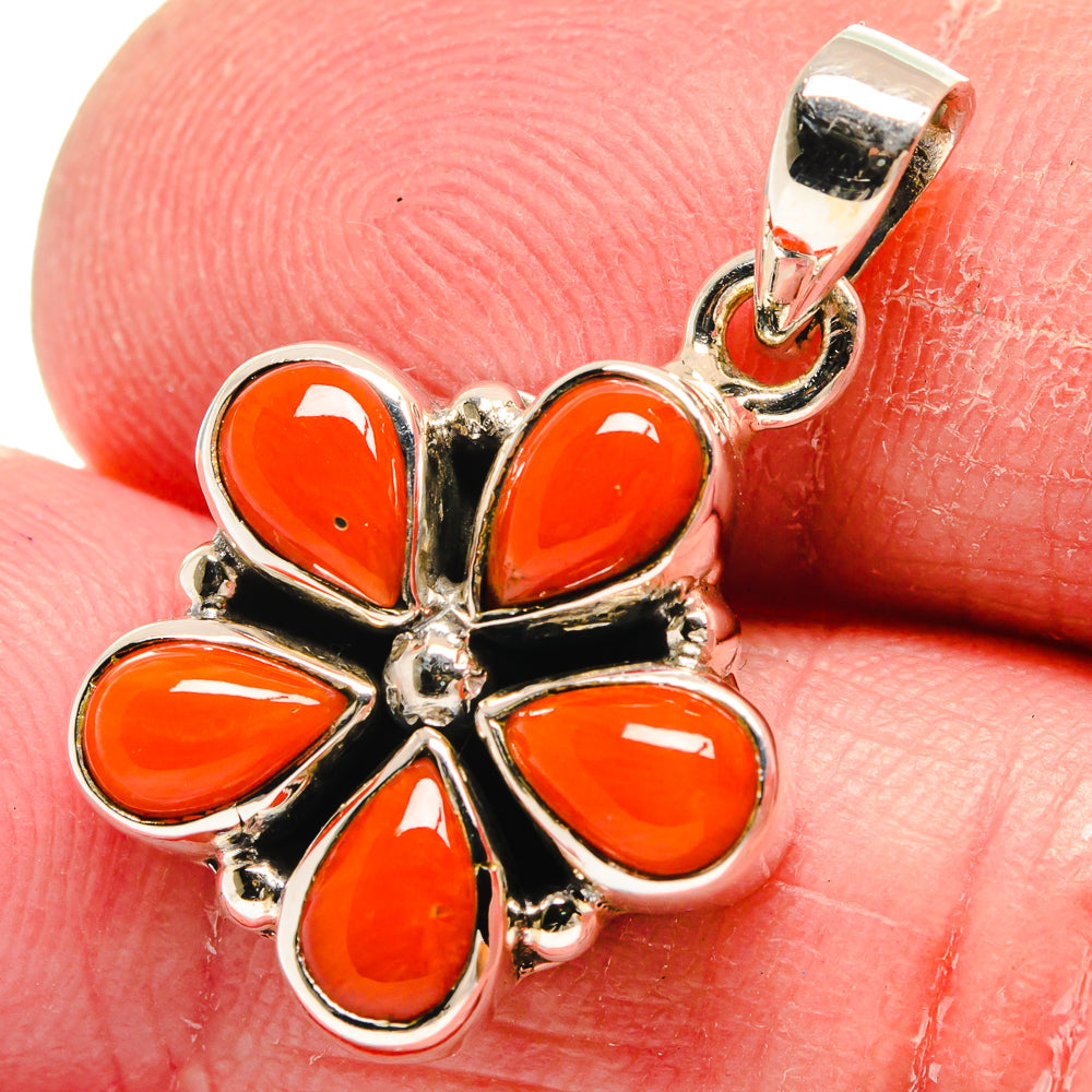 Close-up red coral flower pendant with sterling silver setting and top loop bail