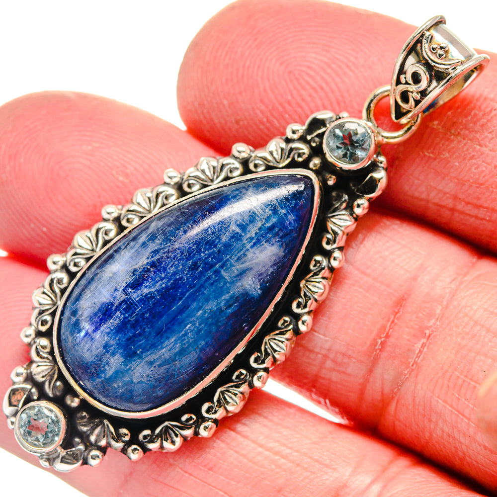 Sterling silver pendant close-up, teardrop blue gemstone with round blue side stones