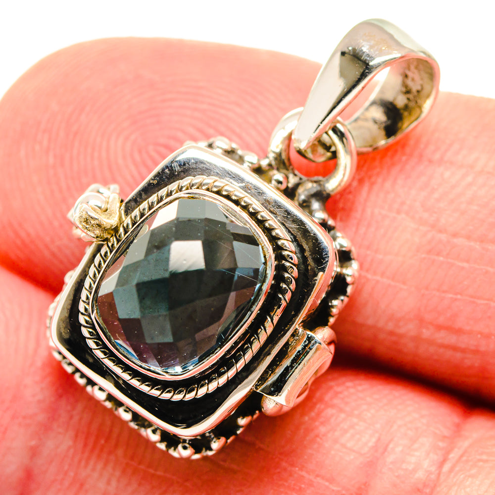 Poison hematite pendant close-up: oval dark green-blue stone in silver frame, bail top