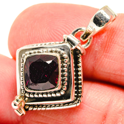 Sterling silver garnet pendant close-up: faceted dark red square stone in ornate bezel