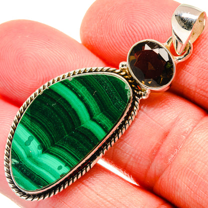Close-up of oval malachite cabochon pendant with dark smoky quartz and silver bail