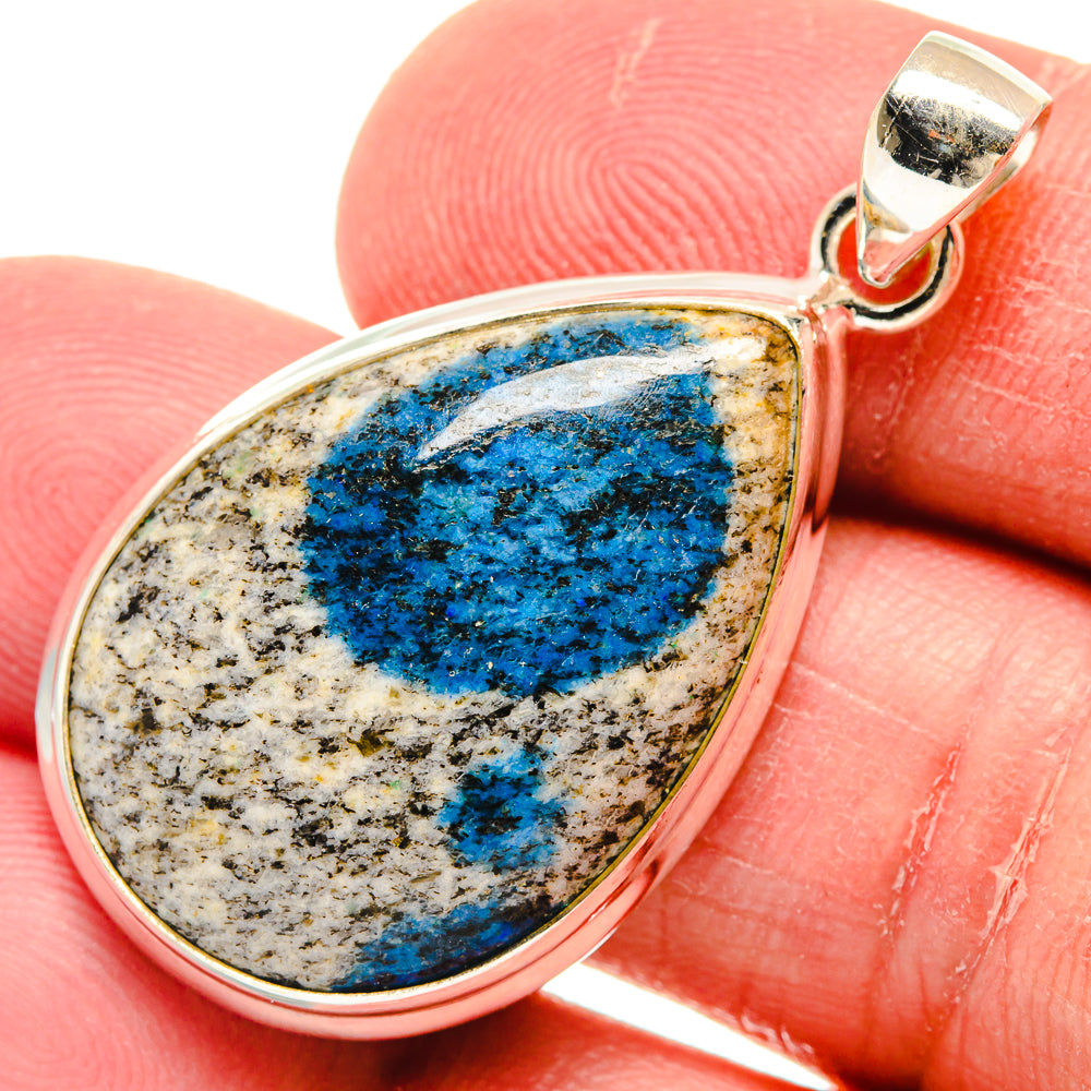 Sterling silver teardrop azurite pendant close-up on blue marbled stone, bail at top