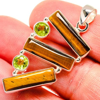 Tiger eye & peridot pendant close-up: orange-brown bars, green round stones, silver bail