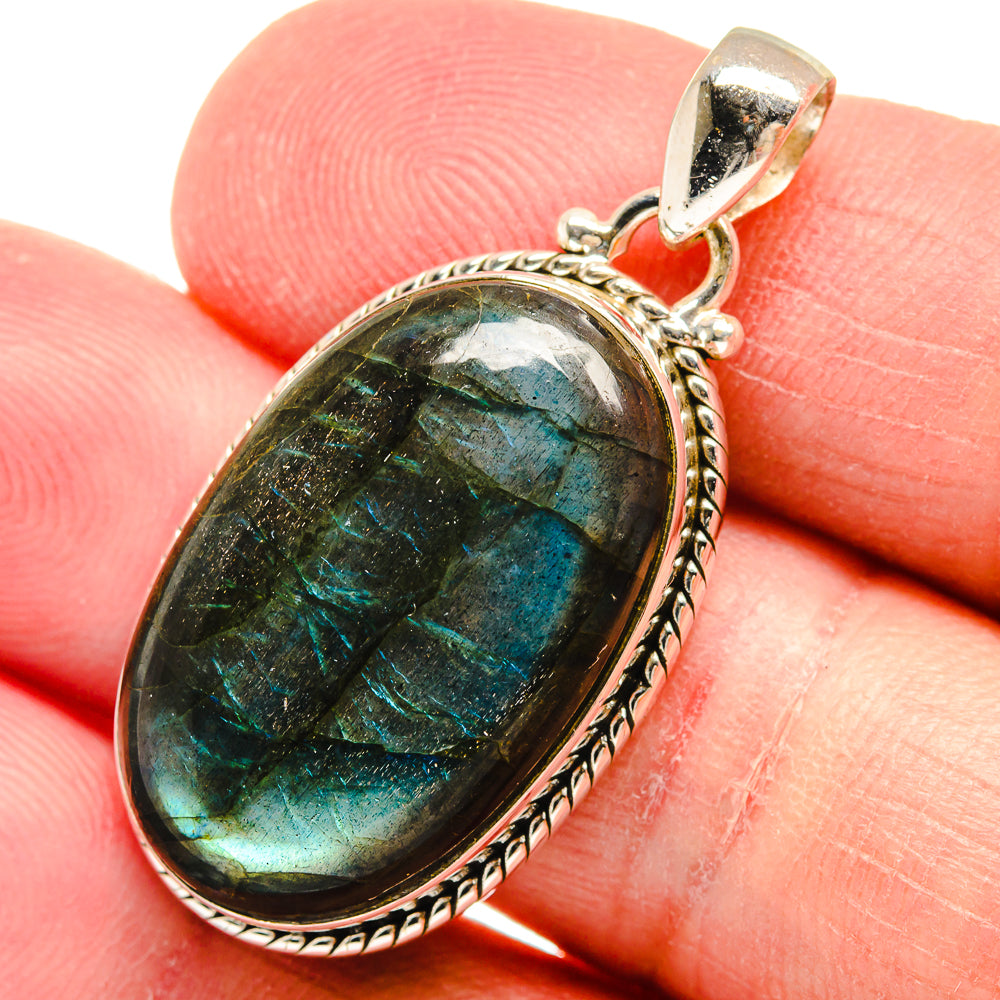 Sterling silver labradorite pendant with oval bezel and iridescent teal-green stone cabochon.