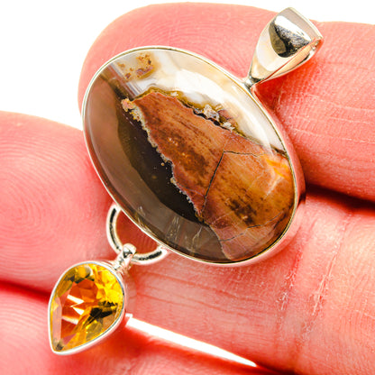 Pendant: Oval butterfly jasper cabochon with citrine teardrop and 925 silver bail on finger