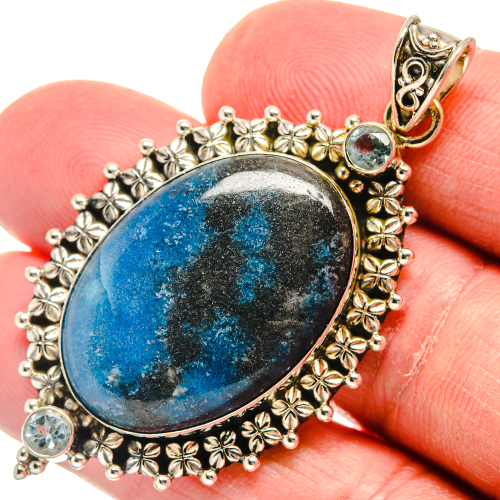 Sterling silver blue topaz pendant close view, oval stone with detailed floral border
