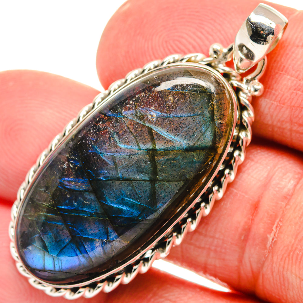 Oval labradorite pendant with silver bezel and bright blue-green iridescence