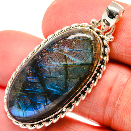 Oval labradorite pendant with silver bezel and bright blue-green iridescence