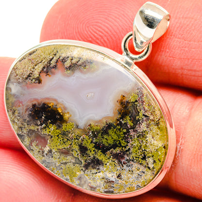 Oval plume agate pendant with yellow-green mossy patterns in silver bezel
