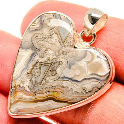 Heart-shaped lace agate pendant close-up in sterling silver with bail, cream and amber bands