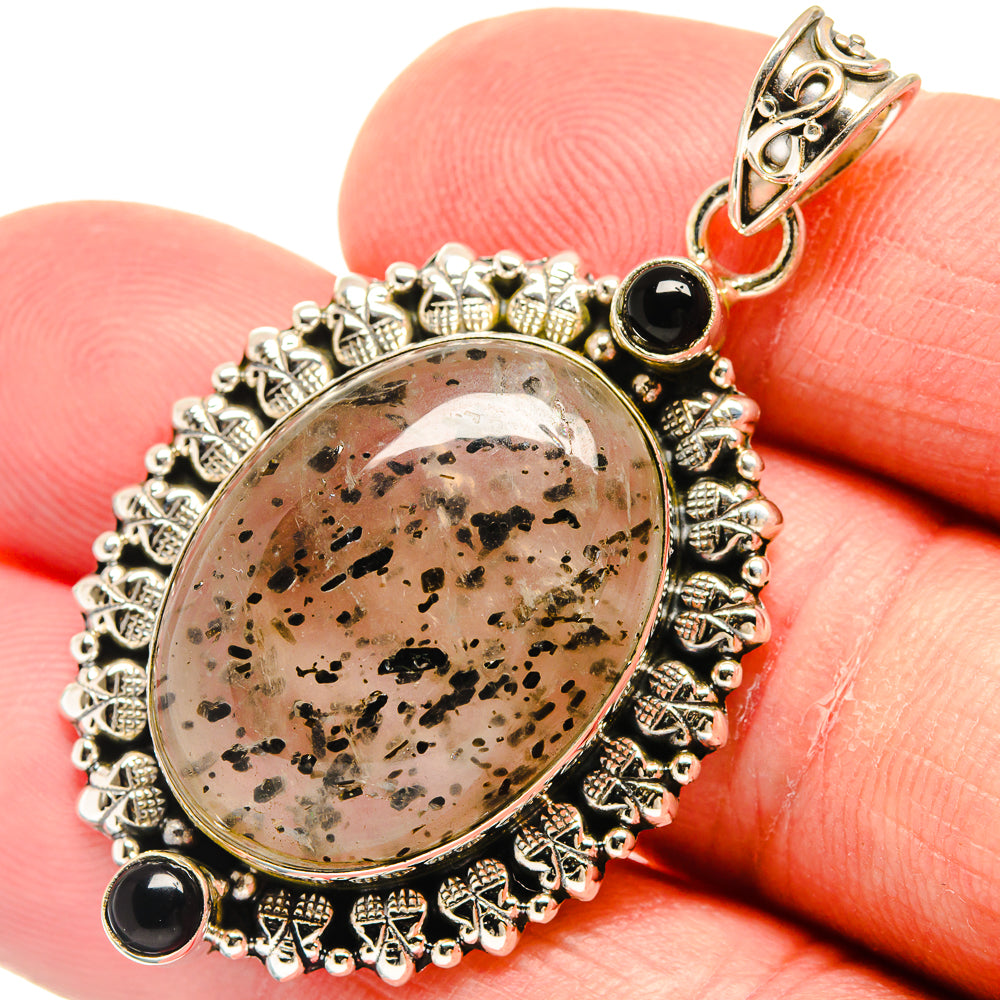 Oval plume agate pendant with black onyx accents, ornate silver-tone bezel and bail