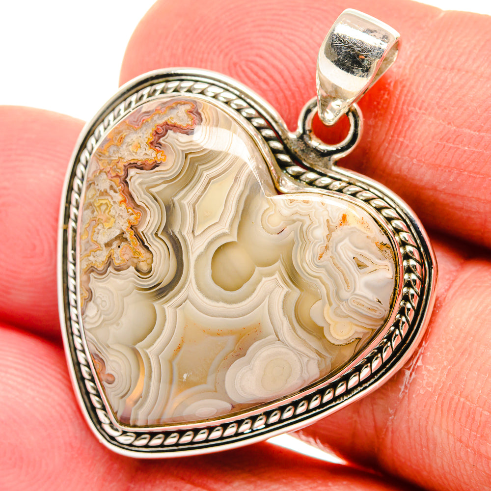 Heart-shaped agate pendant with cream, brown, and gold bands in sterling silver bezel
