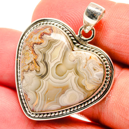 Heart-shaped agate pendant with cream, brown, and gold bands in sterling silver bezel