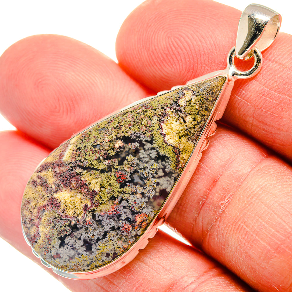 Teardrop plume agate pendant close-up in silver-tone bezel with loop bail