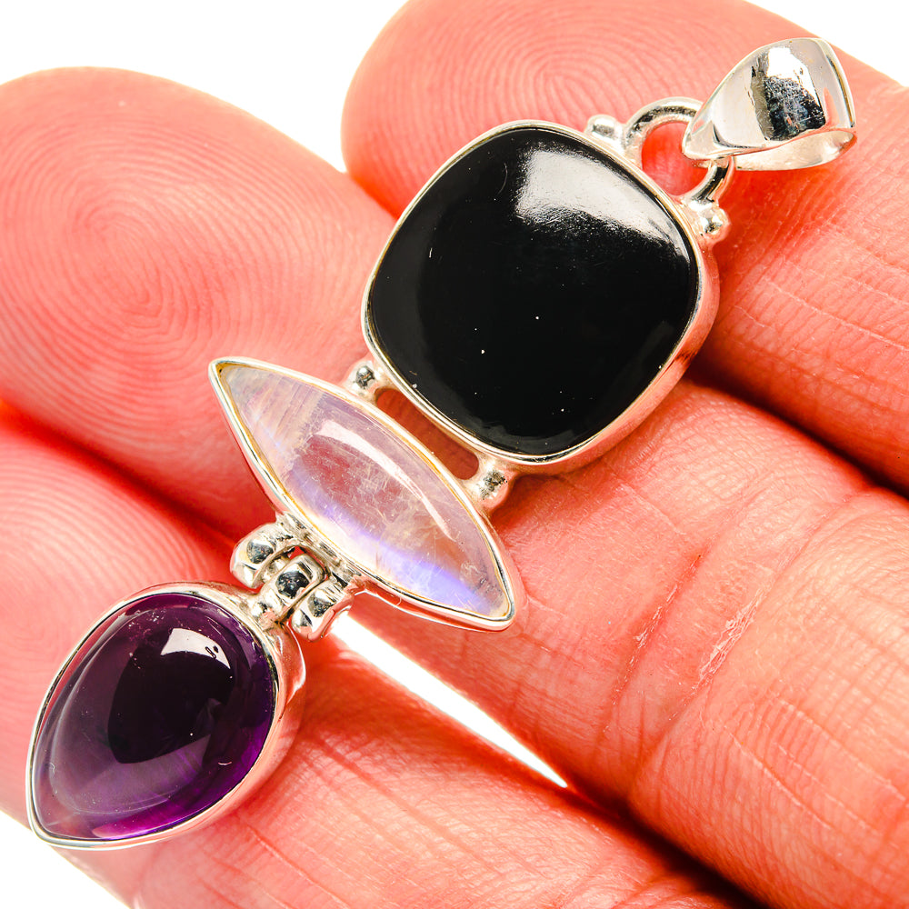 Oval gemstone pendant with black onyx, purple amethyst, and iridescent stone in silver