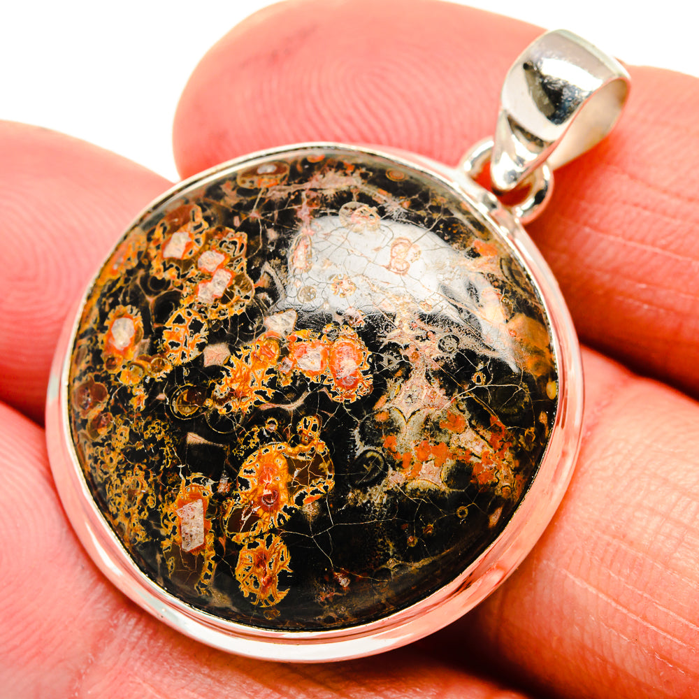 Round sterling silver pendant with black-and-orange speckled stone and metal bail
