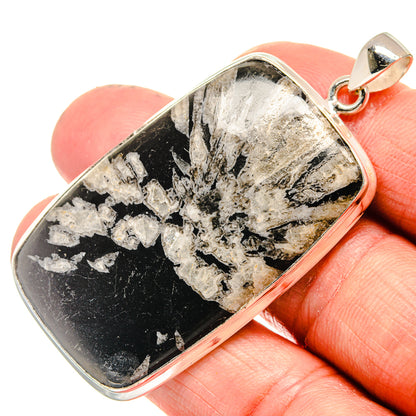 Sterling silver rectangular chrysanthemum stone pendant with loop bail, shown in hand