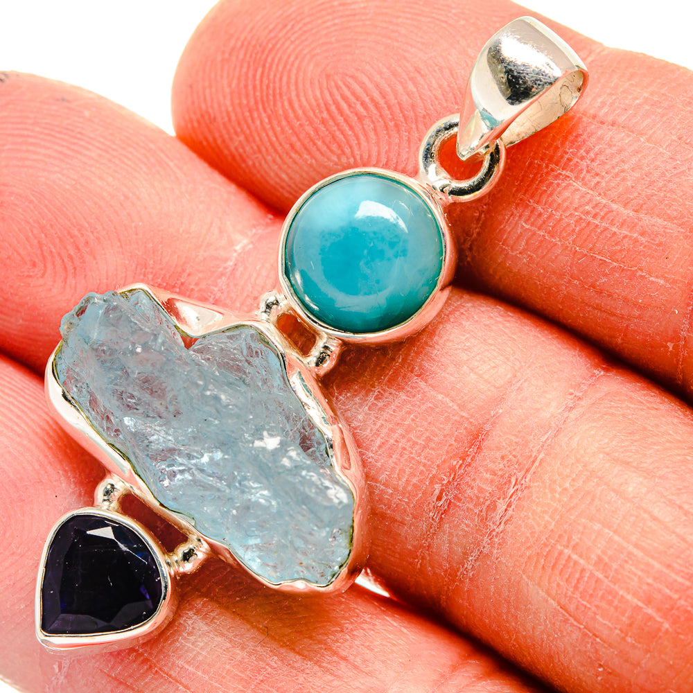 Sterling silver pendant close-up: round turquoise cabochon, rough pale blue stone, purple gem