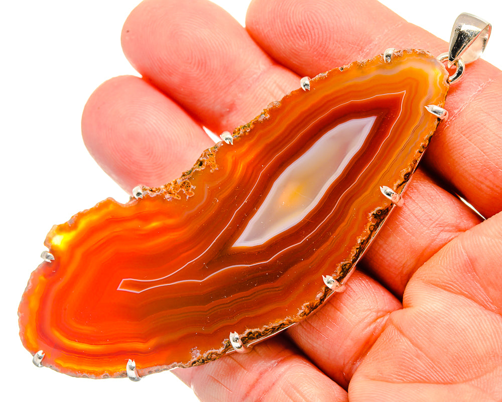 Red/orange geode slice pendant with sterling silver bezel and prong-set edge