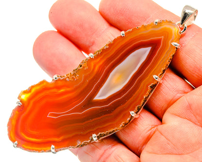 Red/orange geode slice pendant with sterling silver bezel and prong-set edge
