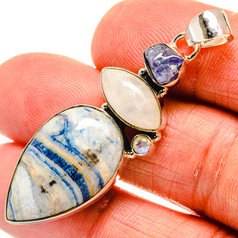 Sterling silver pendant close-up with oval blue scheelite, moonstone cabochons, opal detail