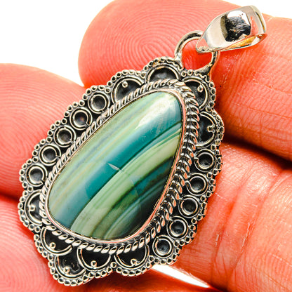 Oval jasper pendant with teal-green striped stone and ornate silver frame