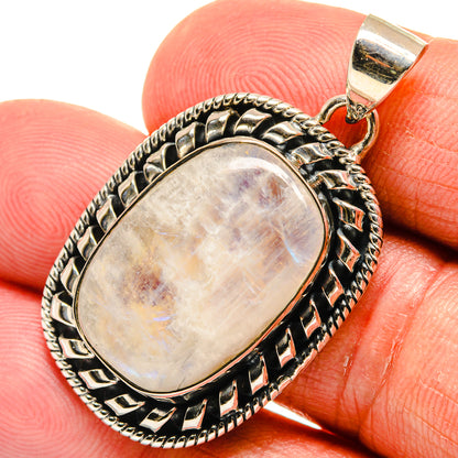 Oval moonstone cabochon pendant with ornate sterling silver bezel and bail