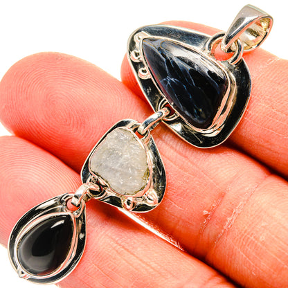 Sterling silver pendant with black onyx teardrop, blue moonstone-like center, and pale oval