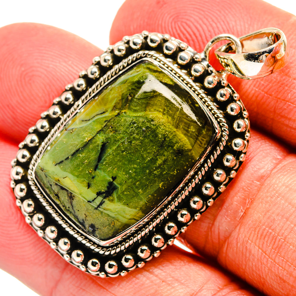 Green opal pendant with beaded sterling-silver frame and heart-shaped bail on finger