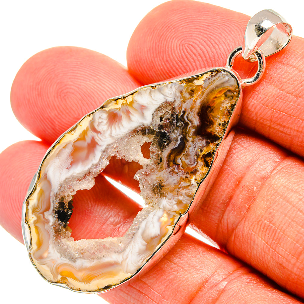 Teardrop druzy pendant with orange, white, and black stone on silver bail