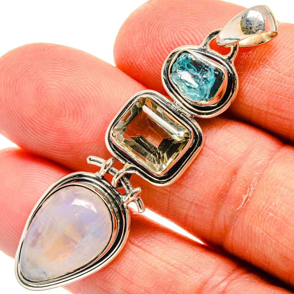 Sterling silver pendant detail with oval opal, rectangular clear stone, and blue-green cabochon