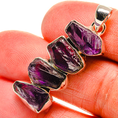 Rough amethyst pendant close-up with purple crystal pieces in silver prong bezels