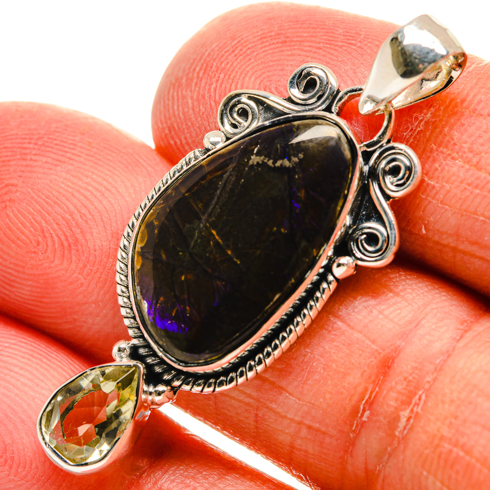 Sterling silver pendant with oval black gemstone, purple shimmer, and small yellow side stone