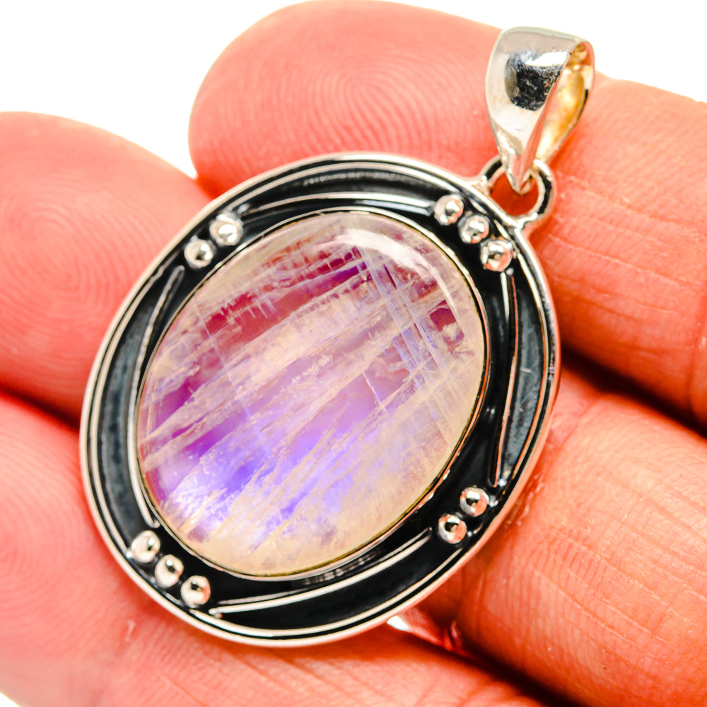 Oval rainbow moonstone pendant with black bezel and beaded border, sterling silver bail