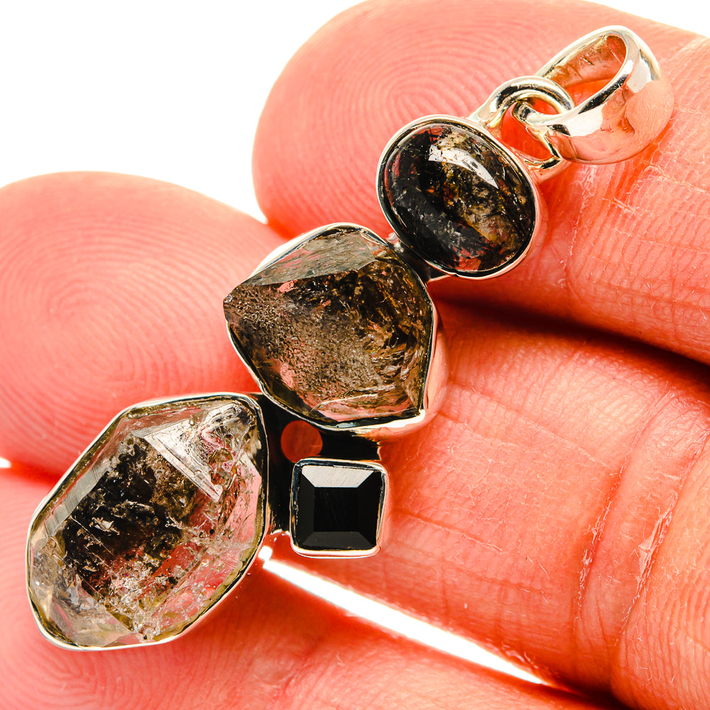 Silver pendant close-up with faceted gold-and-black stones and black onyx square dangles