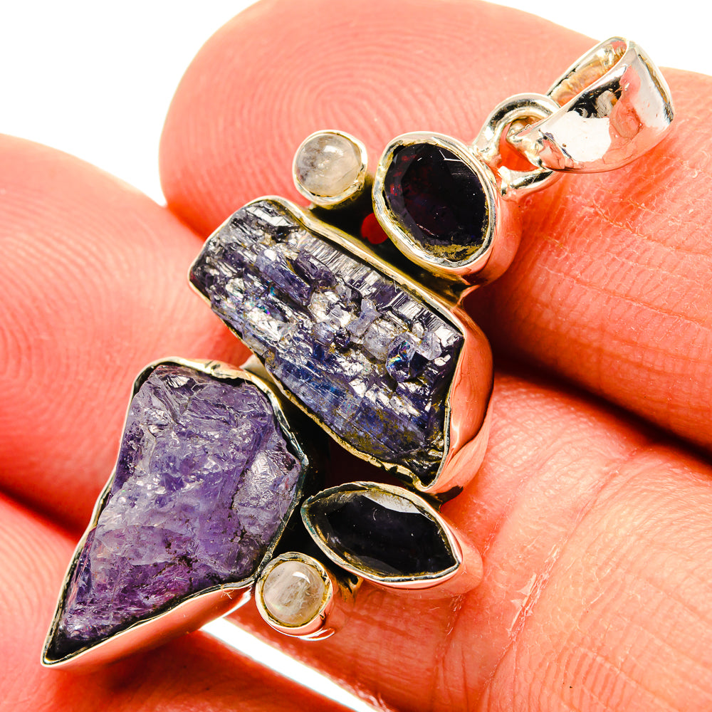 Rough stone pendant close-up: purple crystals, black cabochons, round light accents