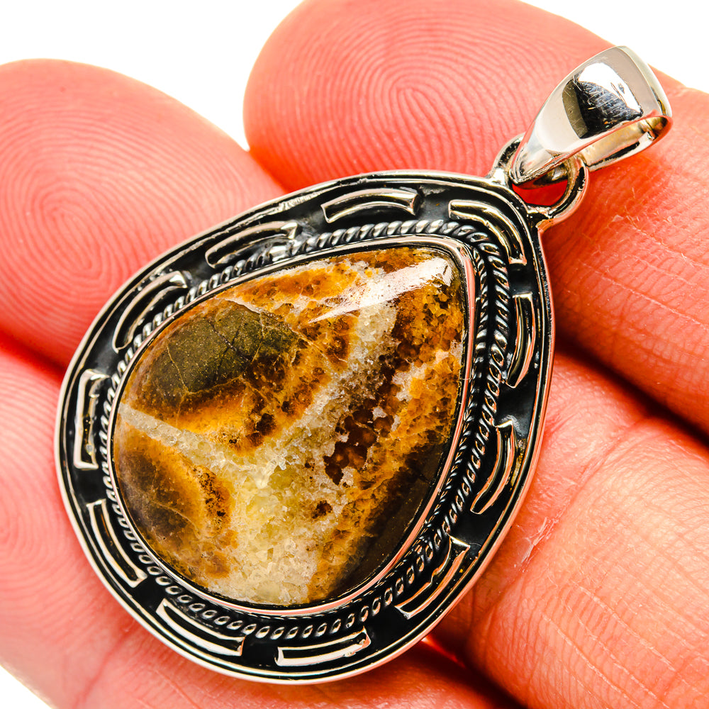 Septarian nodule pendant close-up, oval amber-brown stone in silver beaded bezel and bail