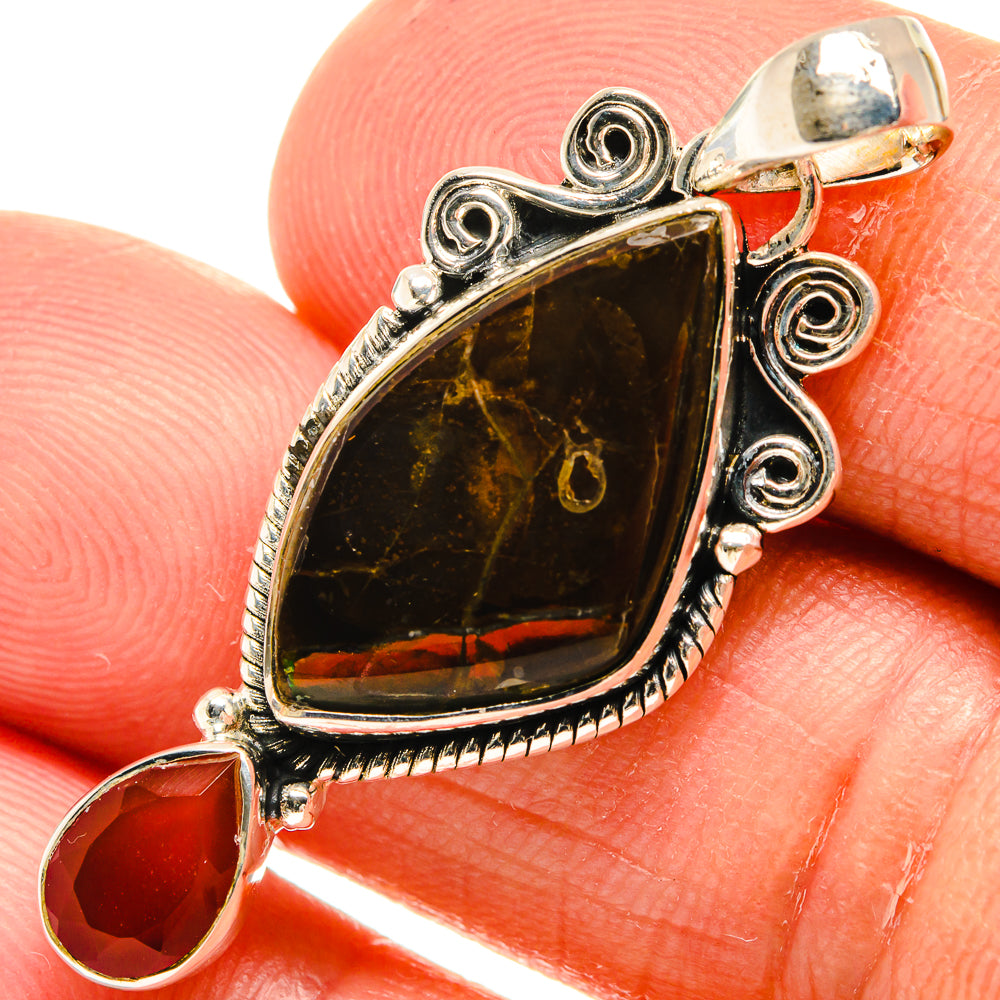 Sterling silver pendant closeup: dark ammolite teardrop with red carnelian drop