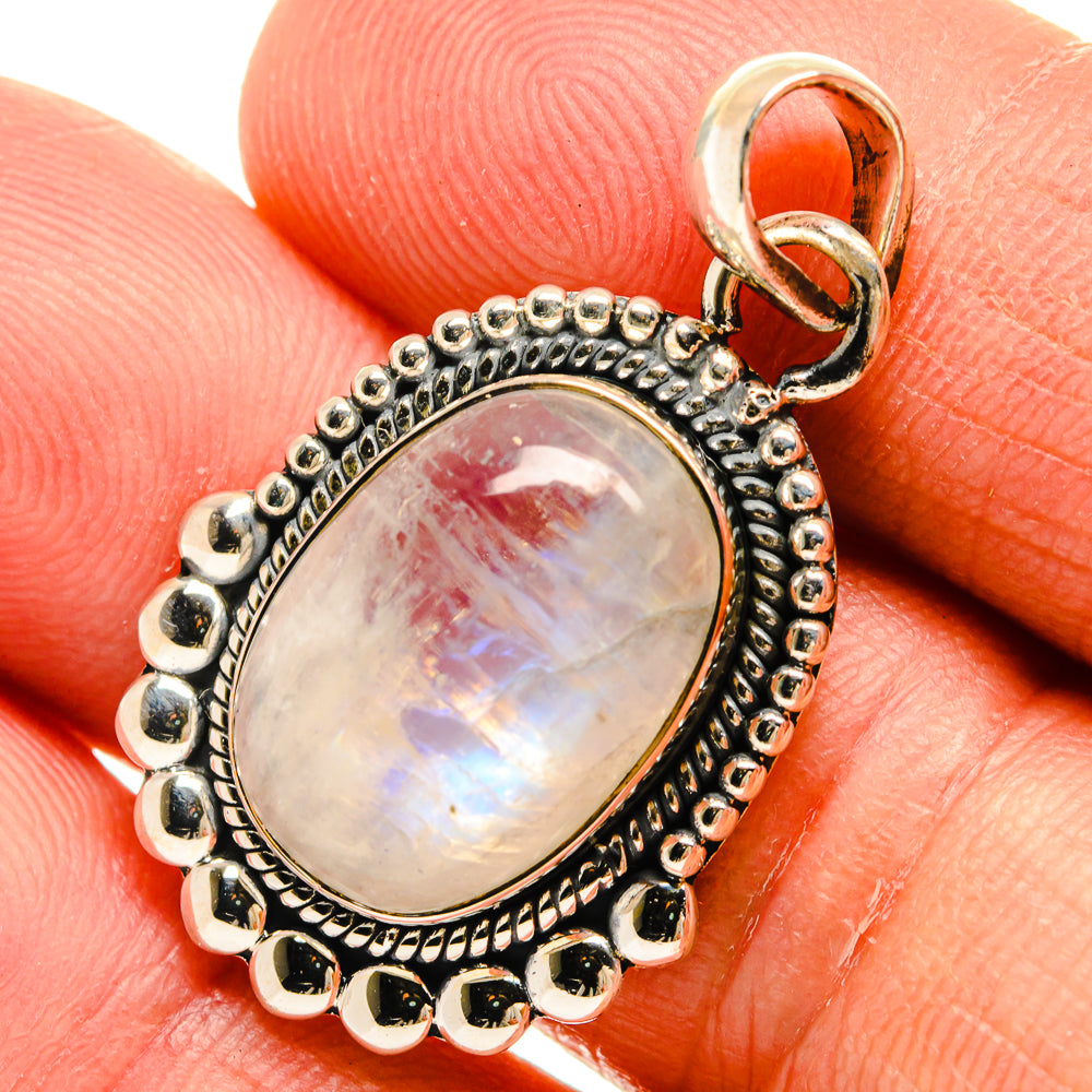Close-up oval moonstone pendant with rainbow sheen, beaded bezel and round silver frame
